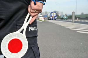 policjant trzyma tarczę do zatrzymywania pojazdów