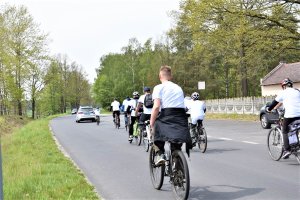 Kolarze jadą za radiowozami.