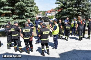 Rozproszona grupa policjantów i strażaków Ochotniczych Straży Pożarnych.