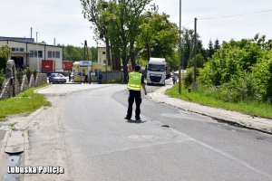 Policjant stojący na drodze.