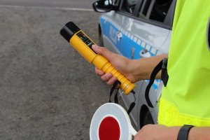 Policjant trzymający w dłoni lizaka i Alcoblow