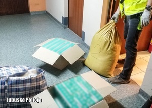 Policjant robi oględziny zabezpieczonych papierosów