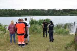 Policjantka i przedstawiciele innych służb kontrolują akwen wodny