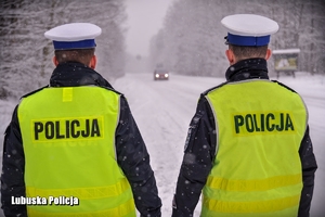 policjanci na ośnieżonej drodze