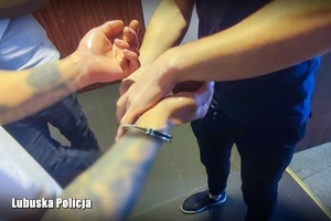 zatrzymany mężczyzna, skuty kajdankami  przez policjanta