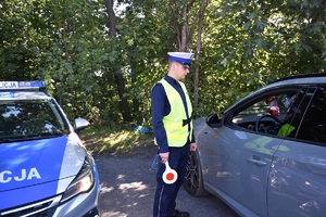 policjant przeprowadza kontrolę drogową