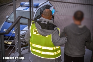 Policjanci prowadzą zatrzymanego mężczyznę