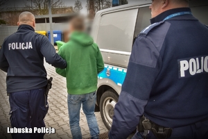 policjanci prowadzą zatrzymanego mężczyznę