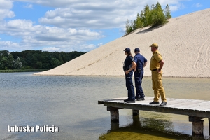 policjanci i strażak nad wodą